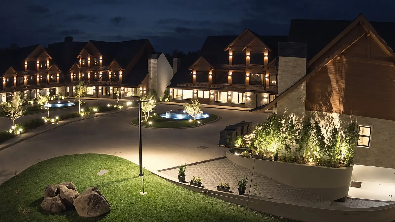 O resort pronto na primeira noite, com as alas de madeira e pedra acesas e a praça iluminada
